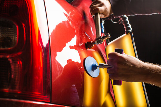 PDR. Professional mechanic removes dents on the car body

