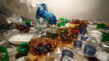 Volunteer cleaning and sorting pile of plastic. Collecting and separating one time use plastic trash. Pollution and environmental problem with homes and household waste management. Save the planet.