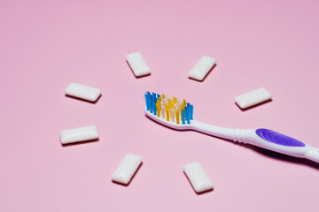 toothbrush and chewing gum pads on a pink background. High quality photo