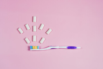 toothbrush and chewing gum pads on a pink background. High quality photo