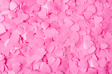 Top high angle close up view photo of pastel color pink heart shape confetti textured background