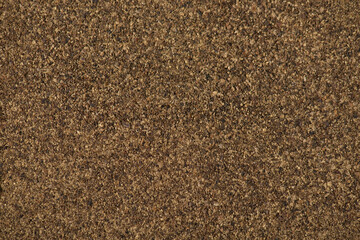 Top close up above view photo of black powder pepper textured background