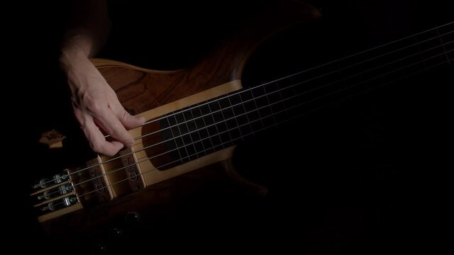 Wood Basssguitar play dark background 4K footage