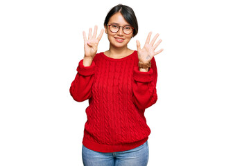 Young beautiful hispanic woman with short hair wearing casual sweater and glasses showing and pointing up with fingers number nine while smiling confident and happy.