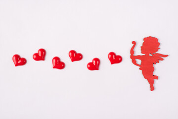 Happy saint valentines day concept. Photo of cute sweet cupid shooting with hearts isolated white background