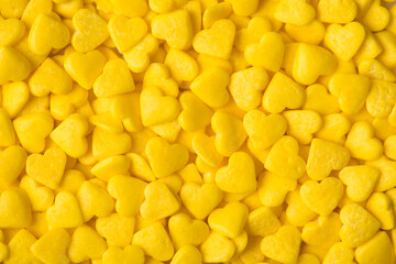 Photo of yellow light hearts sugar sprinkles textured background