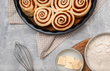 Raw cinnabon buns with cinnamon on ultimate grey backdrop. Ingredients and recipe. Christmas bakery. Flatlay. Kitchen appliances.