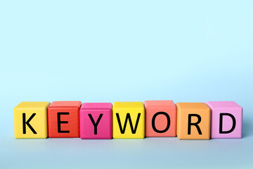 Colorful cubes with word KEYWORD on light blue background