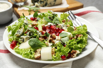 Fresh salad with pear on table, closeup