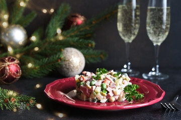 Traditional New Year's salad Olivier. New Year's festive table and glasses of champagne.