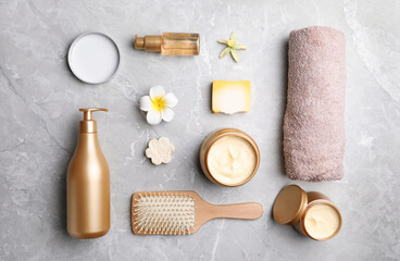 Flat lay composition with hair cosmetic products on grey marble table