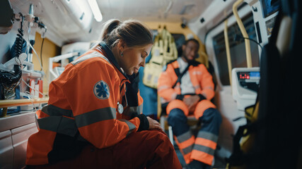Calm and Tired Female EMS Professional Paramedic Mentally Prepares in Ambulance Vehicle on the Way...