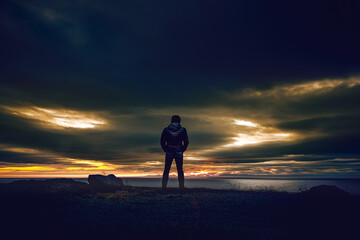 silhouette of a person standing on a rock