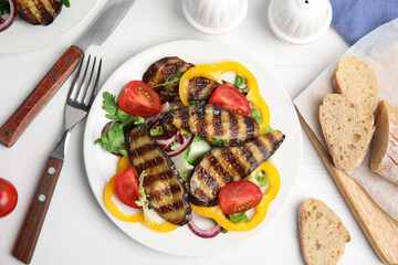 Delicious salad with roasted eggplant served on white wooden table, flat lay