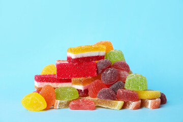 Pile of delicious bright jelly candies on light blue background