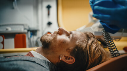 Side View Portrait Shot of an Injured Young Male Patient with Blood Bruising on His Face. Injured Man with a Beard Lying on a Hospital Stretcher. He's Sane and Happy to be Alive.