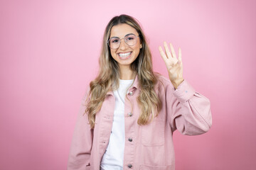 Young beautiful blonde woman with long hair standing over pink background showing and pointing up...