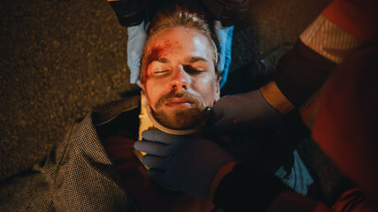 Portrait of a Young Injured Man Lying on the Pavement after Traffic Accident on a Street at Night....