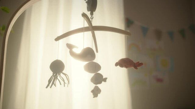 Rotating Wooden Crib Toy with Stuffed Animals Hanging Above Newborn Baby Bed