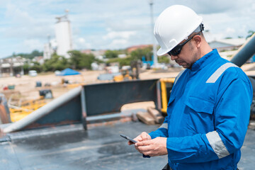 Fototapeta premium Officer of the deck in the maritime ship deck, with cell phone