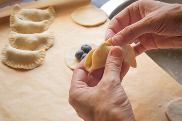 Woman's hands making homemade blueberry dumplings