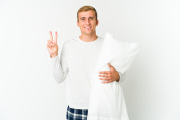 Young caucasian man going to sleep isolated on white background