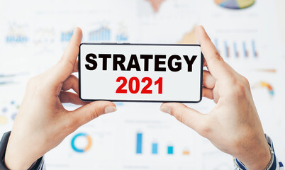 Closeup on businessman holding a smartphone with text STRATEGY 2021.
