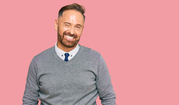 Handsome middle age man wearing business clothes winking looking at the camera with sexy expression, cheerful and happy face.