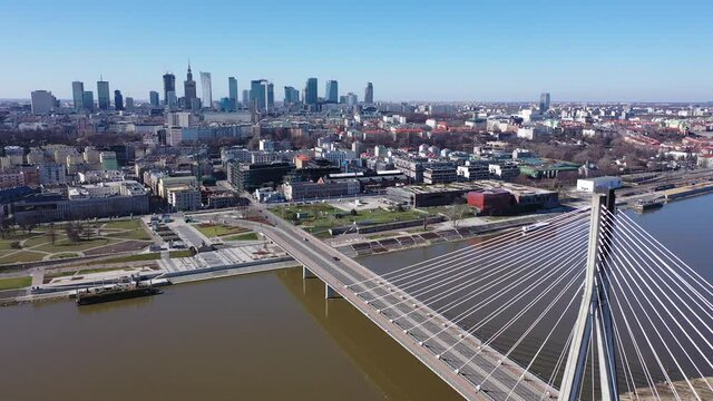 Panoramic view from drone of Warsaw modern cityscape on left bank of Vistula river with cable-stayed Swietokrzyski bridge in spring, Poland