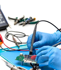 Electronics repair service-the master checks the electronic unit and performs electrical measurements.Oscilloscope and multimeter measuring instruments.