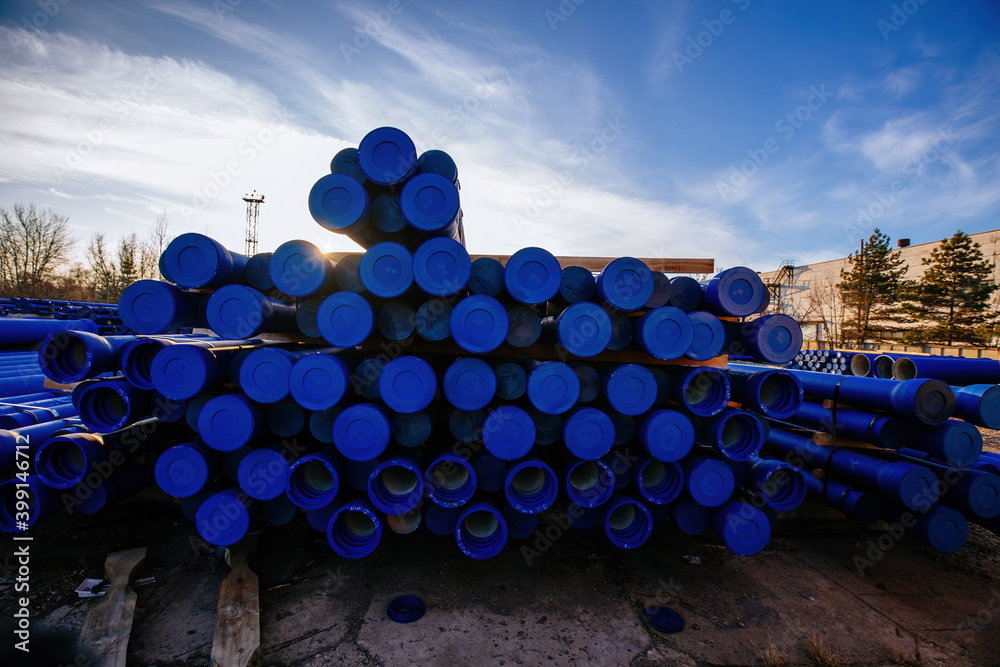 Wall mural Stack of cast iron pipes in loading area waiting for transportation