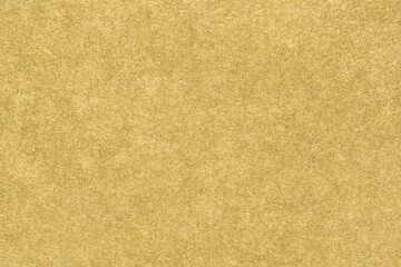 Gold paper texture. Smooth matte golden foil abstract background. Close-up.