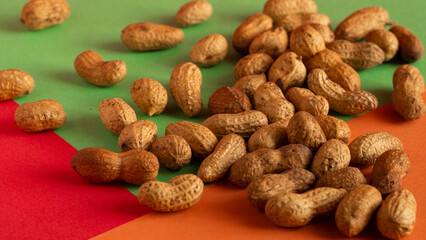 flat lay wave shape of roasted unsalted peanuts, peanuts in skin and peanuts in shell, food ingredients