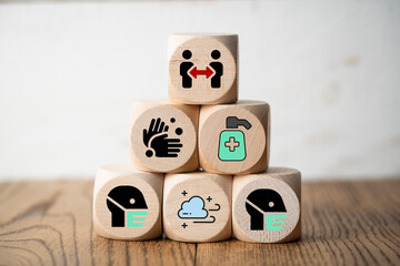 cubes with facemasks, soap and other info icons for good actions in a pandemic on wooden background
