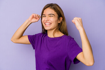 Fototapeta premium Young skinny caucasian girl teenager on purple background celebrating a special day, jumps and raise arms with energy.