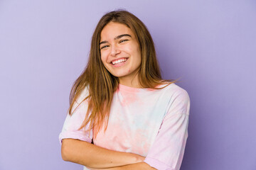 Fototapeta premium Young skinny caucasian girl teenager on purple background who feels confident, crossing arms with determination.