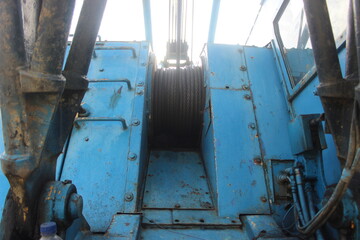 Blue tractor crane in meadow