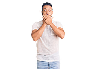 Young hispanic man wearing casual clothes shocked covering mouth with hands for mistake. secret concept.