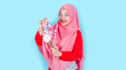 Spring, happiness and celebration concept. Close-up portrait of lovely romantic smiling asian hijab girl, holding flowers, receive bouquet on date, standing on bright background