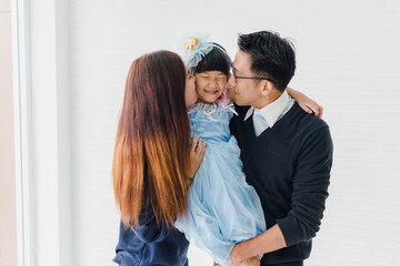 Portrait of an Asian family, parents and daughters smiling happily to be together.