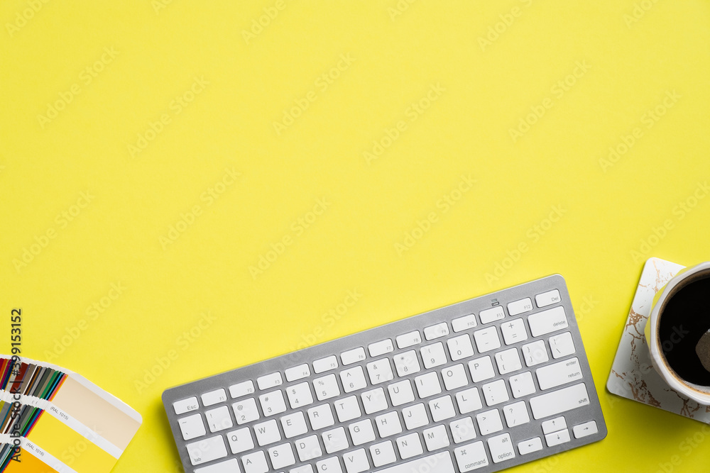 Fototapete Graphic designer desk top view with computer keyboard, color palette, cup of coffee on yellow background. Flat lay, view from above. Creative professional workspace.
