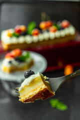 A blueberry on a piece of tasty lemon curd tart with whipped cream and fresh berries on the top. Close up. Vertical orientation.