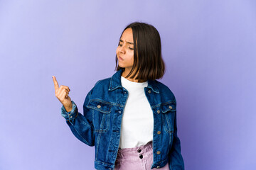 Young mixed race woman pointing with finger at you as if inviting come closer.