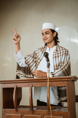 Portrait of muslim male preacher sharing about islam during prayer time in the mosque