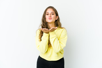 Young caucasian woman folding lips and holding palms to send air kiss.