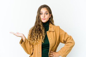 Young caucasian woman showing a copy space on a palm and holding another hand on waist.