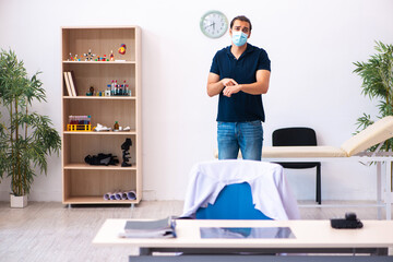 Young man waiting for doctor during pandemic in hospital