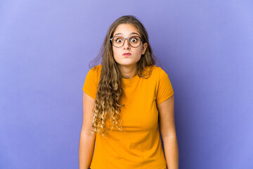 Young caucasian cute woman shrugs shoulders and open eyes confused.
