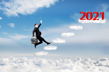 Businessman running on clouds toward 2021 number