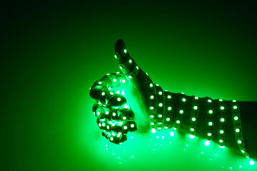 thumbs up hand covered with green led lights, illuminated background